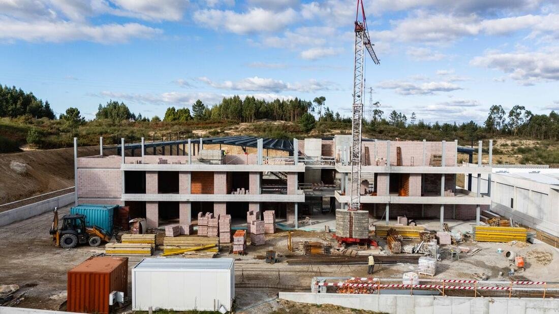 Estrutura do pavilhão industrial em fase de alvenaria, com grua-torre